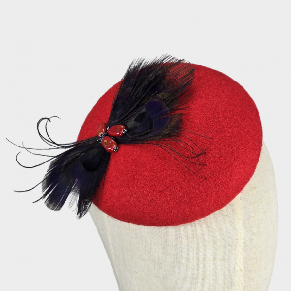 Red felt pillbox hat with peacock feathers